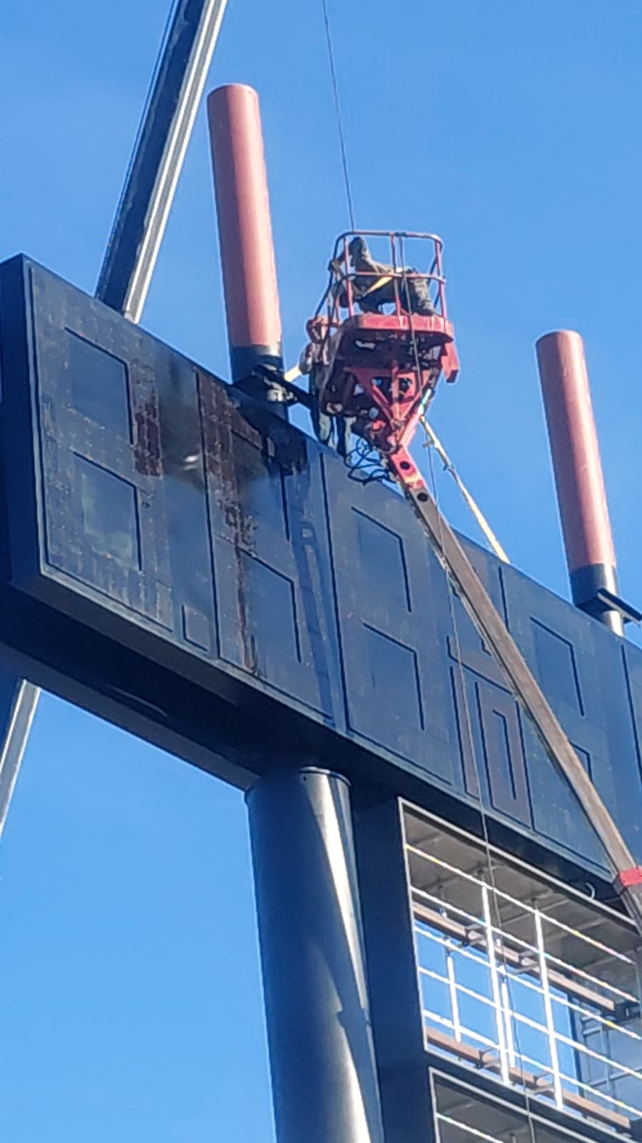 BNext Design installer servicing the upper cabinet of a high-rise sign structure